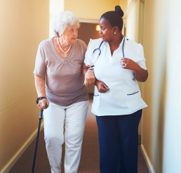 caregiver and elderly woman walking